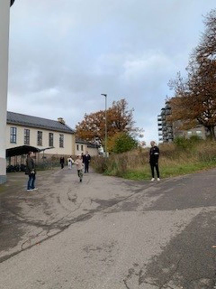 en gruppe mennesker som går nedover en gate med en paraply