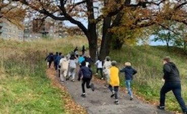 en gruppe mennesker som går på en sti med trær på hver side