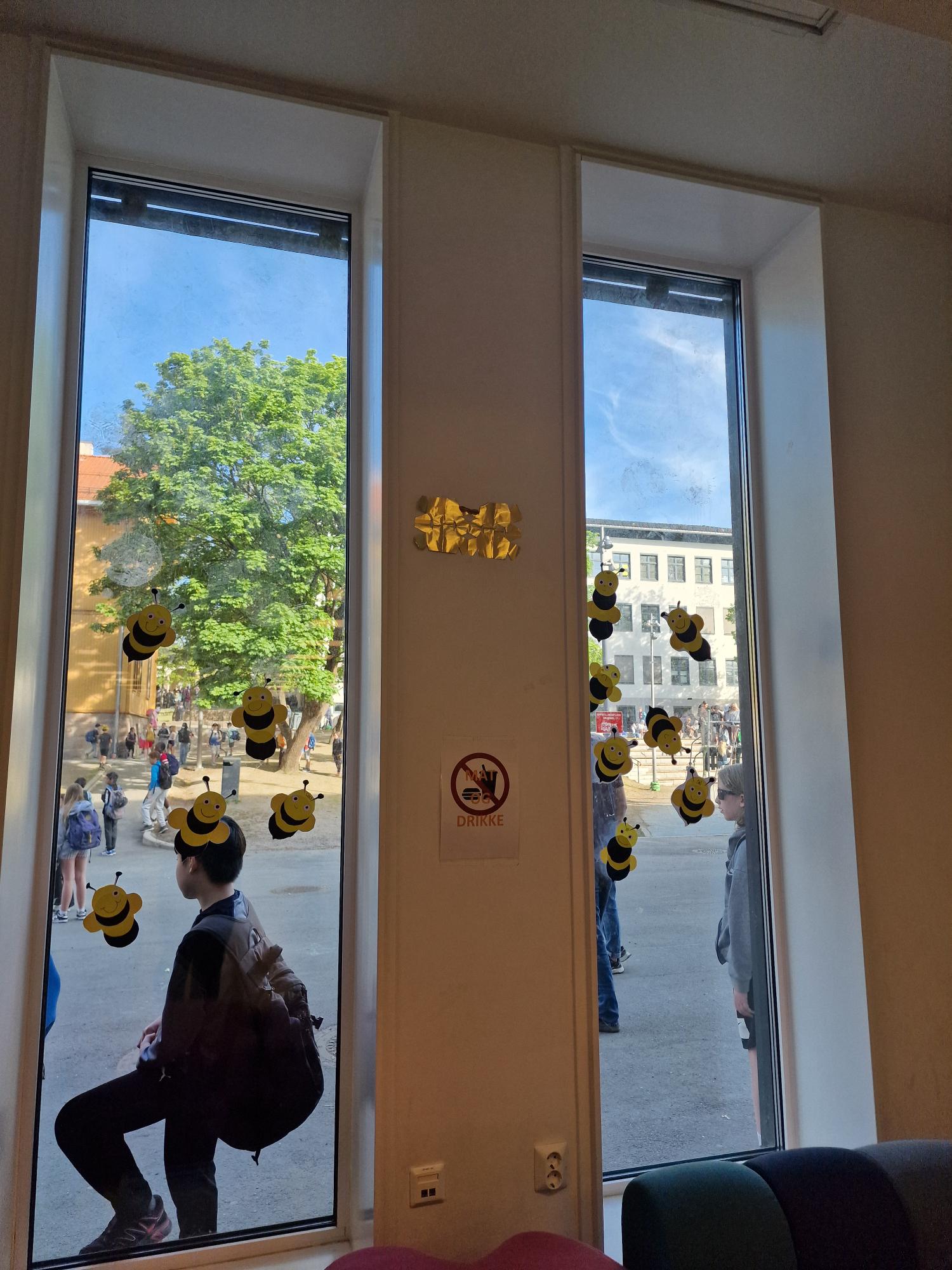 en gruppe mennesker i klær i et rom med et stort vindu