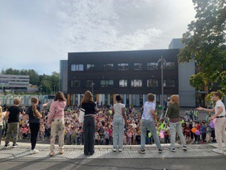 en gruppe mennesker som står utenfor en bygning