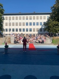 en person som står på en scene foran en stor folkemengde