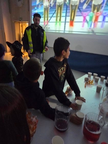 en gruppe mennesker som sitter ved et bord med mat og drikke