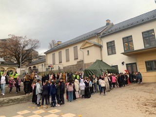 en gruppe mennesker som står utenfor en bygning