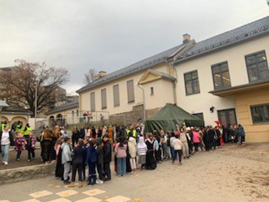 en gruppe mennesker som står utenfor en bygning