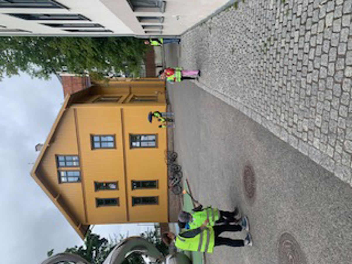 en gruppe mennesker i vester som står utenfor en bygning