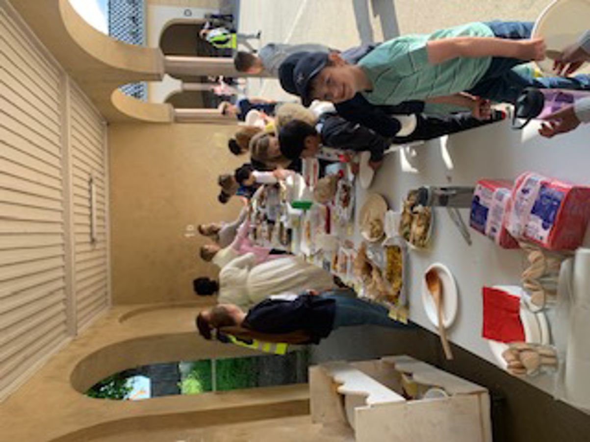 En gruppe mennesker samles rundt et bord fullt av mat