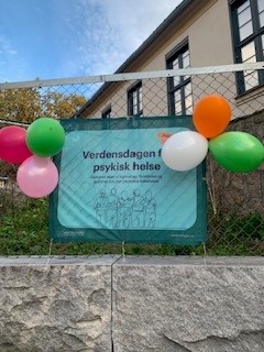 et skilt med ballonger foran en bygning